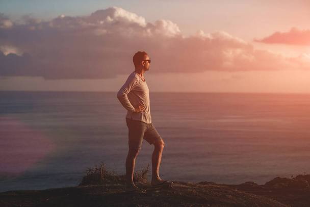 Okyanusun üzerindeki adada tropik yaz günbatımına sahip bir adam.. - Fotoğraf, Görsel