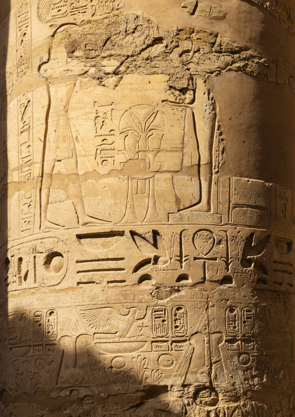 Luxor Governorate, Egipt, Świątynia Karnaka, kompleks Amon-Re. Wytłaczane hieroglify na kolumnach i ścianach. Min jest starożytnym egipskim bogiem.. - Zdjęcie, obraz