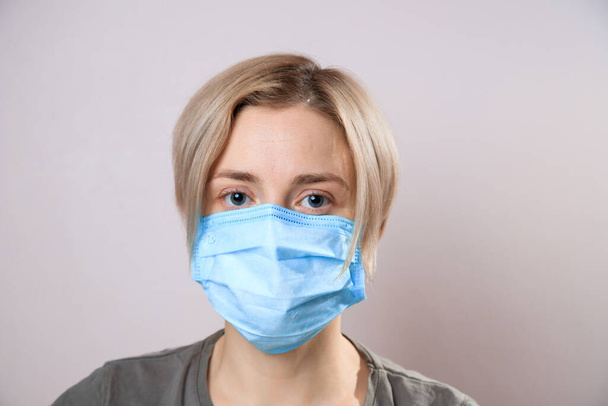 Девушка в маске, чтобы защитить её от вируса Короны. Пандемия коронного вируса. женщина в маске, смотрит в камеру, крупным планом. Эпидемия гриппа, аллергия на пыль, защита от вирусов. Концепция загрязнения воздуха
 - Фото, изображение