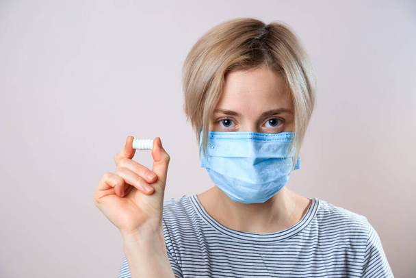 Girl with mask to protect her from Corona virus. Corona virus pandemic. Woman taking lot of white pills. close up. - Foto, Bild