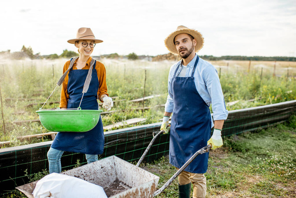 Two workers on the farmland outdoors - Foto, imagen
