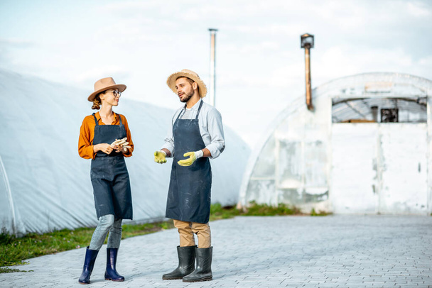 Two farmers on a farm with hothouses outdooors - Fotoğraf, Görsel