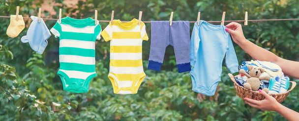 Πλύσιμο των μωρών ρούχα. Τα σεντόνια στεγνώνουν στον καθαρό αέρα. Επιλεκτική εστίαση. Φύση. - Φωτογραφία, εικόνα