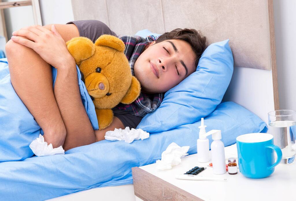 Sairas flunssainen mies makaa sängyssä. - Valokuva, kuva