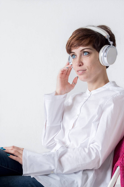 Online education and e-book. self-education. girl is listening to music. Audio book. Beautiful girl listens to an e-book. man in headphones on white. Stylish and beautiful music lover. - Foto, afbeelding