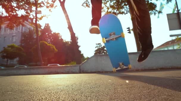 SLOW MOTION: Blue Deck flippt beim Tricksen unter den Füßen des Skateboarders. - Filmmaterial, Video