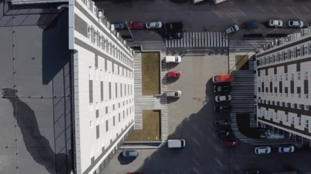 Μετακίνηση μακριά κορυφαία θέα της περιοχής κοντά στην είσοδο των λευκών πολυώροφων κτιρίων, Kharkov, Ουκρανία. Ιδιωτική αυλή με πάρκινγκ για τα αυτοκίνητα κοντά σε ένα πολυώροφο κτίριο το χειμώνα σε ηλιόλουστο καιρό. - Πλάνα, βίντεο