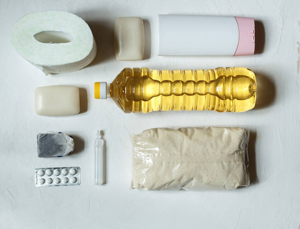 flatlay de papel higiénico, tabletas, jabón, aceite y té sobre un fondo claro
 - Foto, imagen