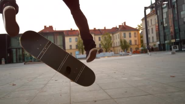 CLOSE UP: gördeszkás srác földdel egy hamis kickflip a gyönyörű főtéren. - Felvétel, videó