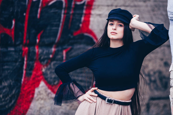 Fashion Portrait of Stylish Pretty Brunette. Young Woman Outdoor. Cool hipster student woman. Trendy hipster Russian teenage girl wearing wearing casual clothes. City lifestyle stylish hipster girl. Trendy outfit - Valokuva, kuva