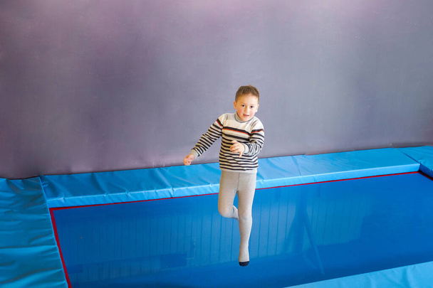 Glücklich lächelnde kleine Kinder springen auf Indoor-Trampolin im Vergnügungszentrum - Foto, Bild