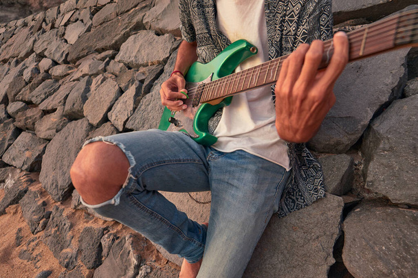 İspanya, Kanarya Adaları, Tenerife sahilinde elektro gitarlı bir çocuk. - Fotoğraf, Görsel