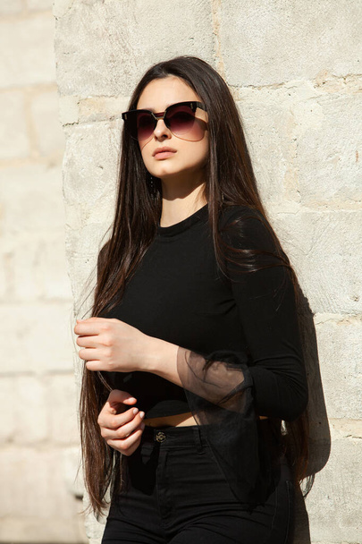Retrato de moda de beleza de menina bonita morena jovem com cabelo preto longo usando óculos de sol. Rosto menina russa beleza com pele natural. Glamour europeu. Menina muito hipster em óculos de sol
. - Foto, Imagem