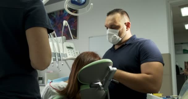 Οδοντίατροι που εργάζονται με ασθενή στο γραφείο - Πλάνα, βίντεο