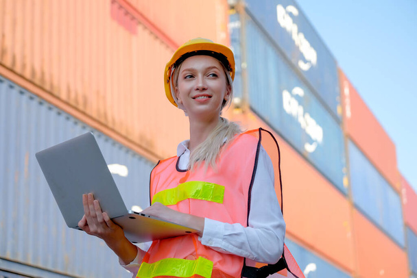 Portrait of beautiful technician use laptop in front of cargo containers with day light. - Φωτογραφία, εικόνα