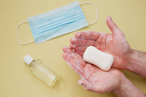 proteção durante o conceito de surto de vírus: limpeza das mãos masculinas com uma barra de sabão
 - Foto, Imagem
