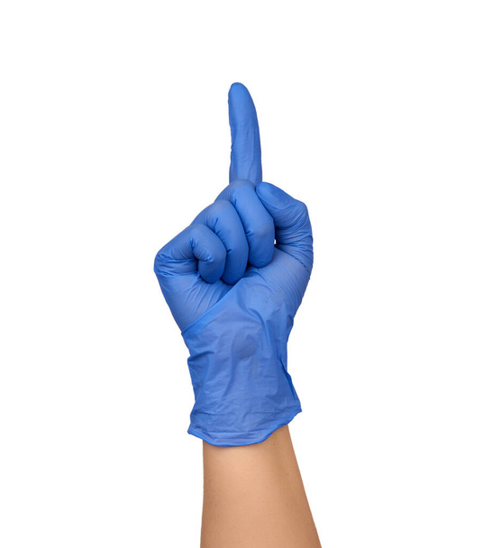 женская рука в синей медицинской стерильной перчатке показывает жест, указательный палец поднят вверх, часть тела изолирована на белом фоне, концепция внимания
 - Фото, изображение