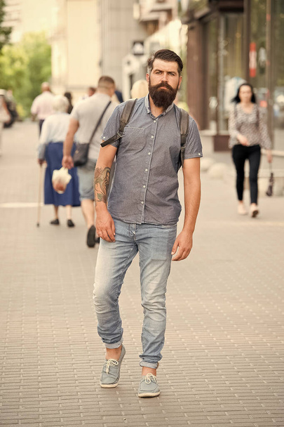 Guy exploring city. Comfortable tourism. Summer vacation. Sightseeing concept. Backpack for urban travelling. Hipster wearing backpack urban street background. Bearded man travel with backpack - Zdjęcie, obraz