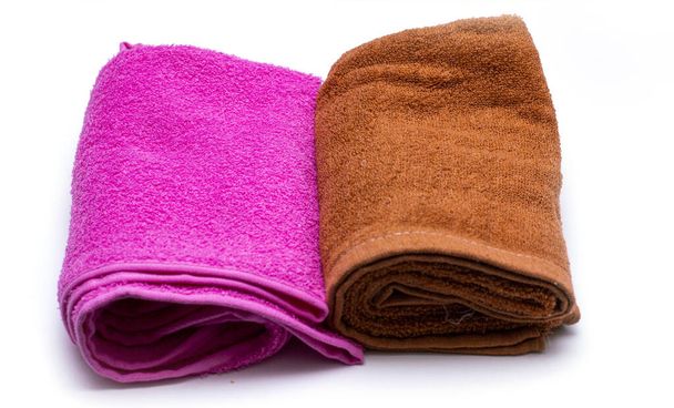 zwei Handtücher mit roter und brauner Farbe auf einer weißen Fensterbank. Farbige Baumwollhandtücher im Badezimmer verwenden. Handtuch-Konzept. - Foto, Bild