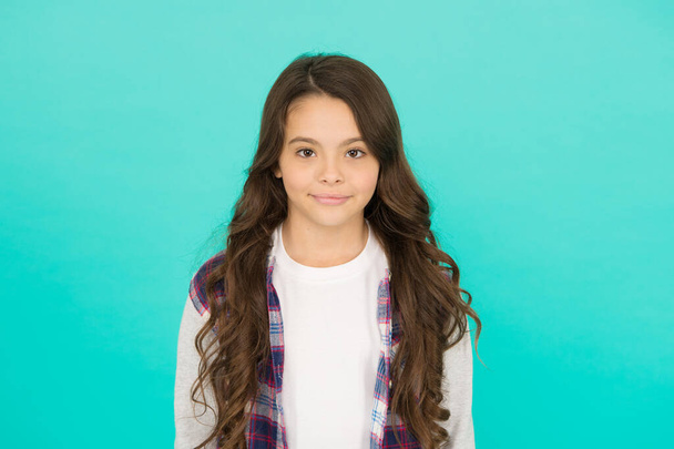 Fashion shop. Shopping day. Feeling cool. Cute girl with long hair. Small girl checkered shirt. Happy international childrens day. Little girl turquoise background. Good mood concept. Positive vibes - 写真・画像