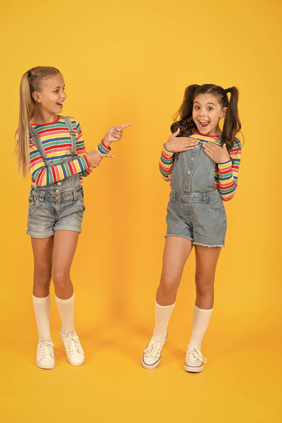 Best friends. Trendy and fancy. Emotional kids. Fashion shop. Modern fashion. Kids fashion. Little girls wearing rainbow clothes. Happiness. Girls long hair. Cute children same outfits communicating - Фото, изображение