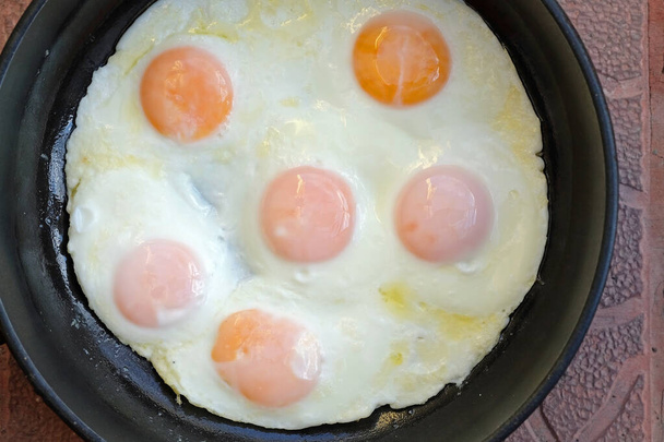 Смажені яйця на сковороді зверху. Шість смажених яєць в маслі, смачний і здоровий сніданок
. - Фото, зображення