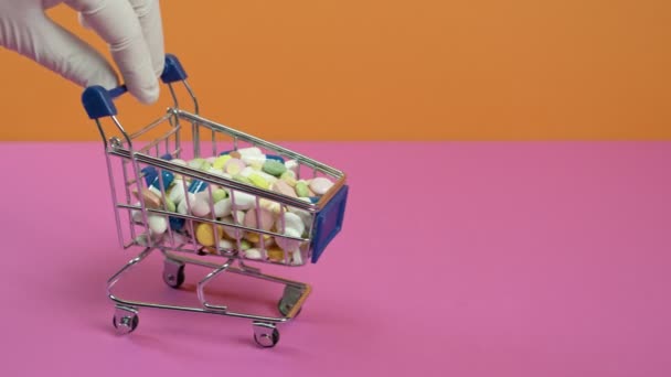 Hand pushing a mini trolley with pills. - Materiał filmowy, wideo