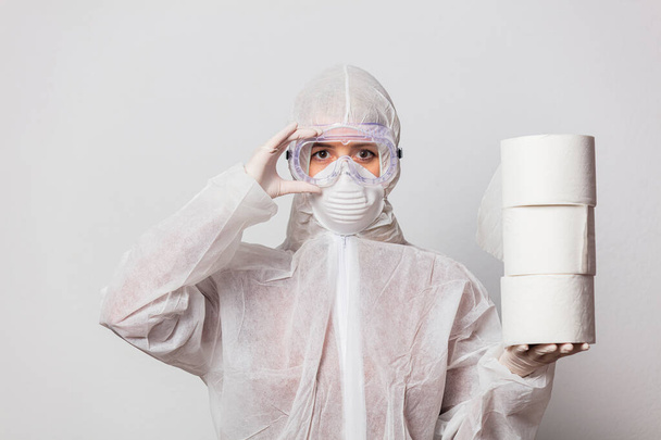 young doctor in protection suit and glasses with mask with toilet paper on white background - Foto, Imagem
