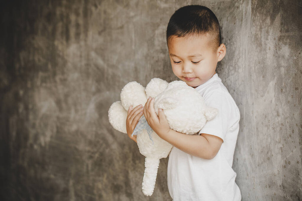 Young boy cuddling teddy bear with sad face, Family violence concept. - Photo, Image