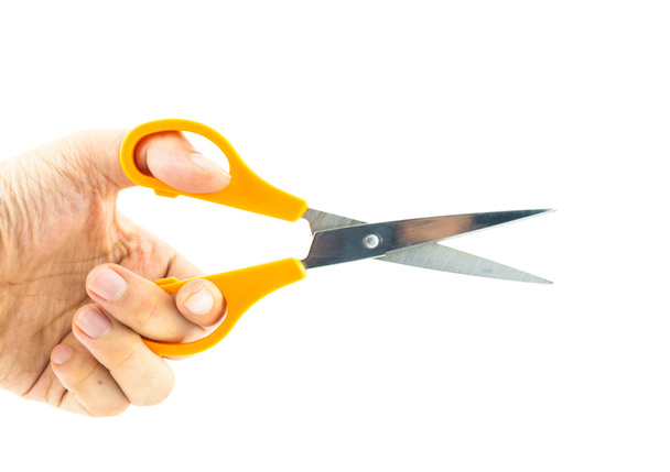 ruka drží používá oranžové nůžkový, izolovaných na bílém pozadí - Fotografie, Obrázek