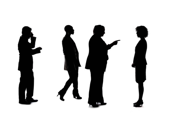Silhouetten van een groep werknemers die een bedrijfs- of netwerkevenement afbeelden. De zakenmannen en -vrouwen zijn onherkenbaar en anoniem en vertegenwoordigen een kantoorteam of -personeel.. - Foto, afbeelding