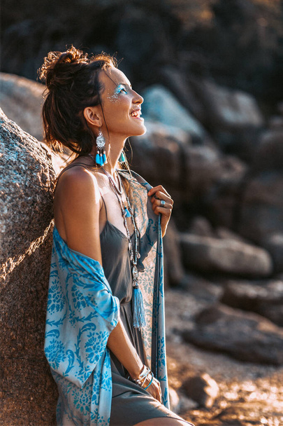 красивая молодая стильная женщина на пляже на закате - Фото, изображение