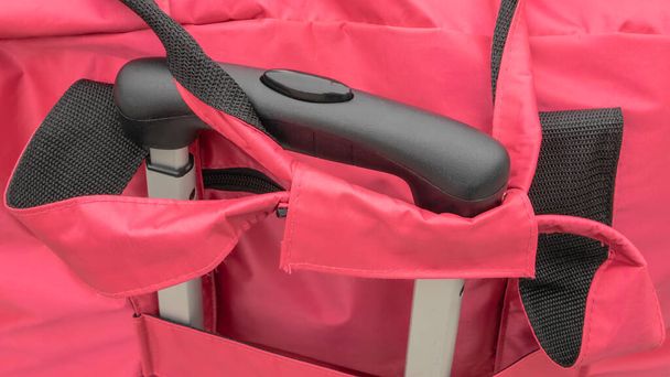 Le gros plan de la poignée de bagages de voyage avec sac de transport rose
. - Photo, image