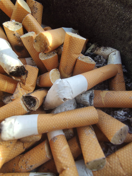 niedopałki papierosów na szarym tle tkane bambusem  - Zdjęcie, obraz