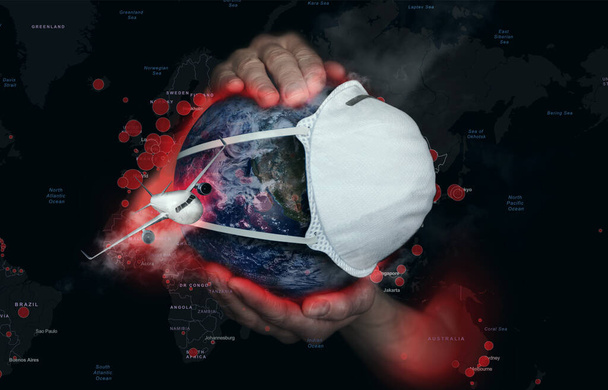 Female hands hold the Earth in a medical protective mask on the background of a map with foci of infection during the epidemic Covid19. Concept - Photo, Image