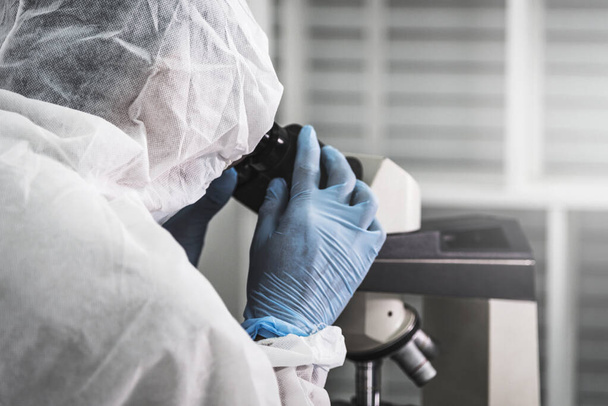 Científico masculino haciendo coronavirus covid-19 con paño de protección para investigación de vacunas en laboratorio biológico
. - Foto, imagen