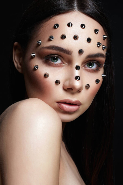 beautiful girl with steel spikes on her Face. Beautiful woman with Halloween Make-up. Beauty Portrait - Valokuva, kuva