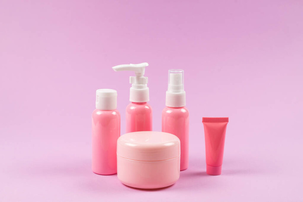 Ροζ πλαστικά μπουκάλια για προϊόντα υγιεινής, καλλυντικά, προϊόντα υγιεινής σε ροζ φόντο. Αντιγραφή χώρου.  - Φωτογραφία, εικόνα