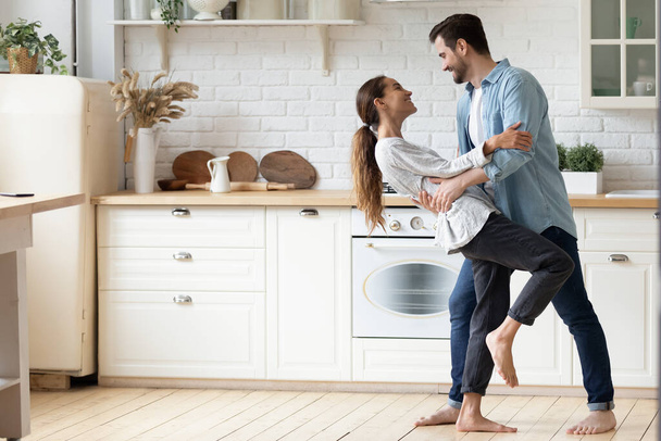 Happy loving couple dancing romantic dance on date in kitchen - Photo, Image