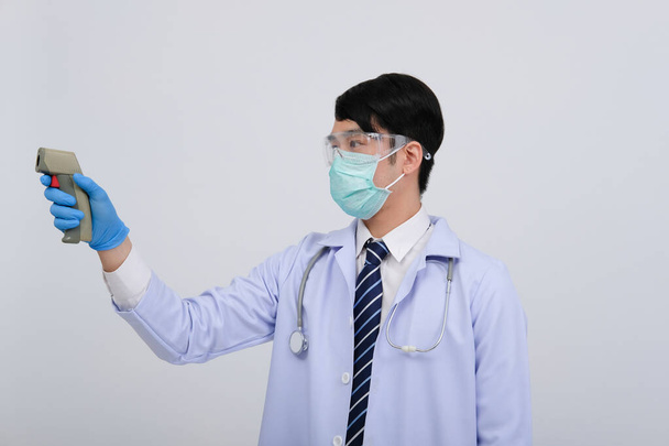 lääkäri lääkäri lääkäri mittaamalla kehon lämpötilaa kontaktiton infrapuna otsa lämpömittari ase
 - Valokuva, kuva
