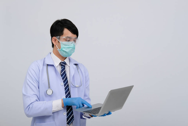 médico médico practicante con máscara con computadora y estetoscopio sobre fondo blanco. medicina profesional medicina concepto de salud
 - Foto, imagen