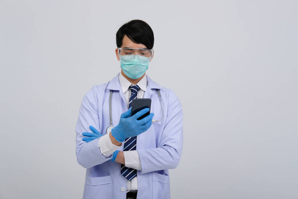 médico médico praticante usando máscara com smartphone e estetoscópio em fundo branco. medicina profissional médica conceito de saúde
 - Foto, Imagem