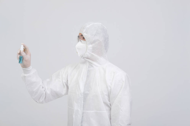 mężczyzna lekarz noszący biologiczny mundur ochronny ubranie, maska, rękawiczki z podajnikiem alkoholu do dezynfekcji bakterii wirusowych - Zdjęcie, obraz