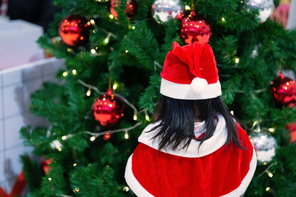 Portrait of cute asian little girl wear santa dress happy near christmas tree - Fotografie, Obrázek