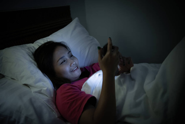 Asian woman playing game on smartphone in the bed at night,Thailand people,Addict social media - Fotoğraf, Görsel