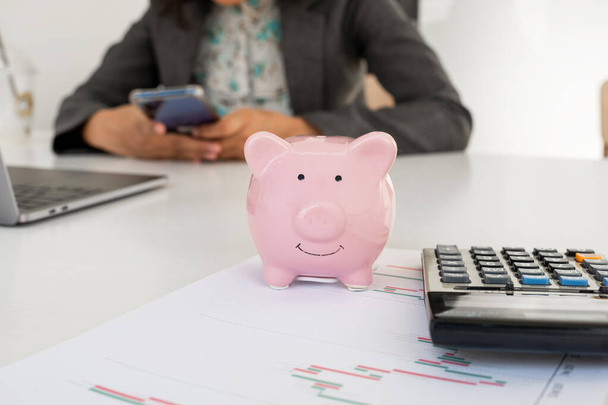 Piggy bank rosa com mulher de negócios no escritório, economizando para o novo alvo de negócios e conceito de aposentadoria
. - Foto, Imagem