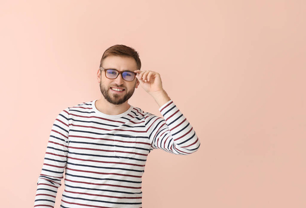 Young man with stylish eyeglasses on color background - Foto, Imagen