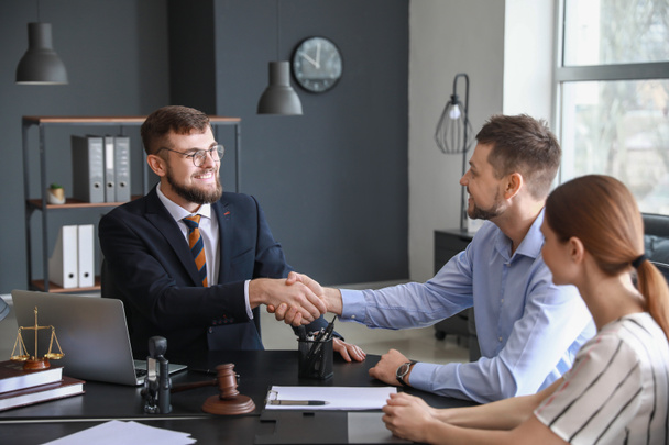 Abogado masculino con cliente estrechando la mano en la oficina
 - Foto, Imagen