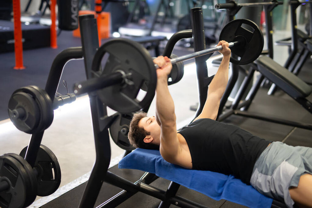 Bodybuilder training by lifting a weight on the flat bench - Fotó, kép