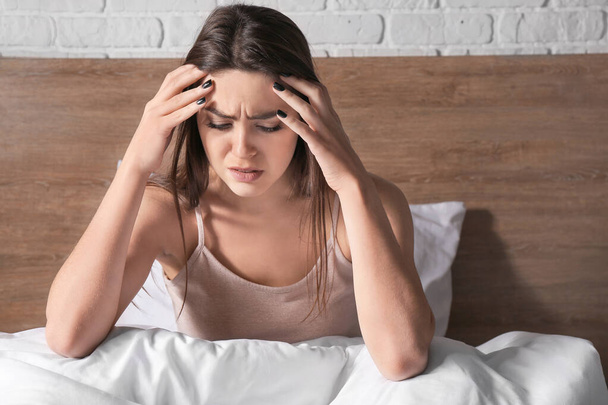 Depressed young woman in bedroom - Foto, Imagen